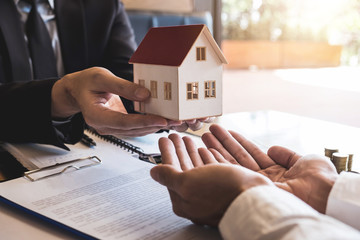 Estate agent sending house model to client after signing agreement contract real estate with...