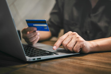 Businessman holding credit card and typing on laptop for online shopping and payment makes a...