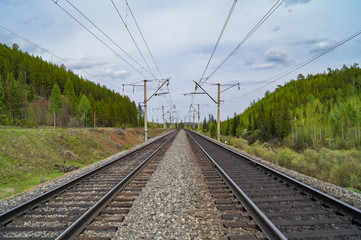 Fototapeta na wymiar Railway tracks go into the distance. Railway on the background of green hills