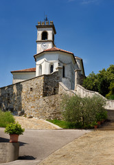 Fototapeta na wymiar White catholic church of Saint Leonard with chain and clock belfry in Dolnje Cerovo Gorica Hills Brda Slovenia