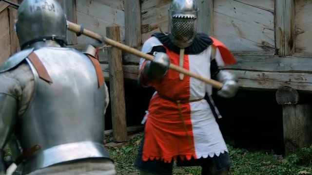 Two militant medieval knights fighting at historical festival. Fantasy, history, reenactment and medieval culture concept
