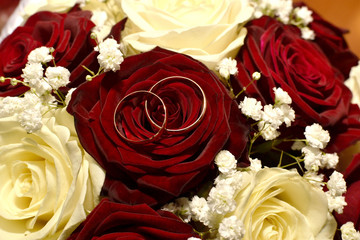 Wedding rings on a bouquet of red and white roses