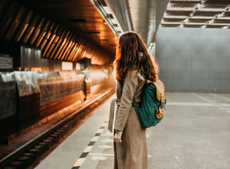 Young woman curly red head girl traveller with backpack and map in subway station