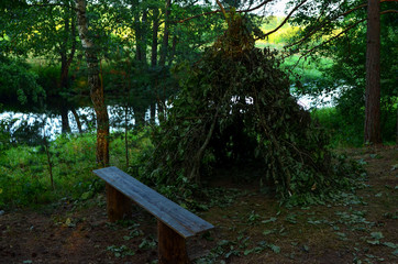 Hut from the branches of the tree for the night in the forest during a journey through the wild nature in the Republic of Belarus on the river Bobr. Camp on the river in the forest fishing and hunting © MaxSafaniuk