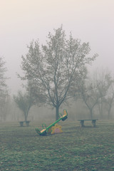 Empty children's playground on a foggy autumn morning