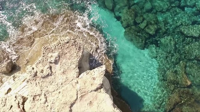 Aerial overhead ascending view of the Cyprus coast with beautiful green waters.