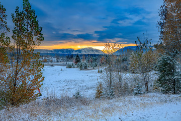 sunrise in mountains behind a small railroad town, Whitefish, Montana, in late October