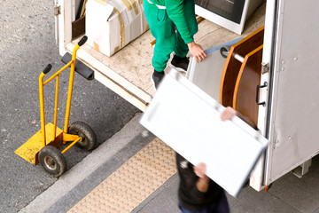 removal truck and delivery man in city street