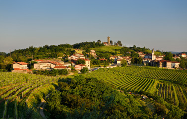 Fototapeta na wymiar Evening light on the vineyards and church of the Holy Cross and Church of the Assumption of Mary in the Gorizia Hills at Kojsko Brda Slovenia