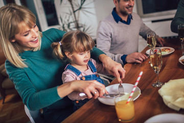 Multi generation family enjoying meal around table at home