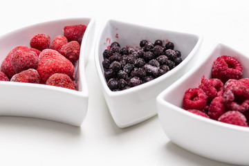 fresh blueberries, raspberries and strawberries in bowl on white background