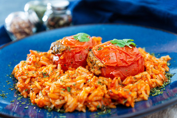 stuffed tomatoes with rice on a white plate
