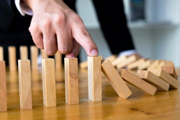 Business finger stops domino continuous overturned meaning that hindered business failure. Stop...