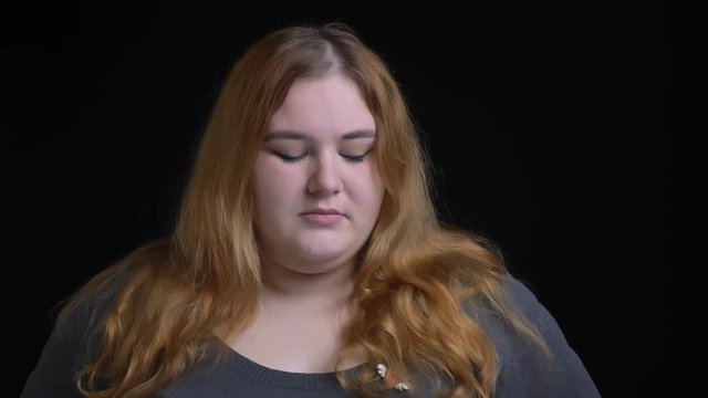 Closeup shoot of overweight caucasian female being upset and depressed looking straight at camera and being close to cry