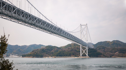 Landscape photo of the first bridge on the Shimanami Kaido cycling route going from Onomichi which connects Mukoujima Island and Innoshima Island in the Shikoku Region of Japan.