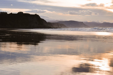  Beautiful sunset on the beach of sopelana with warm tones and an incredible sky. vizcaya, basque country, spain