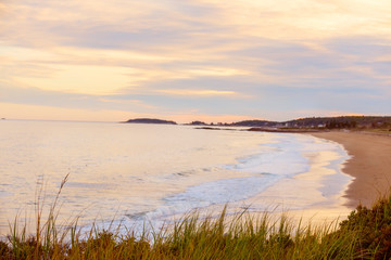 The conquest of the Atlantic Ocean. View from the wild coast to the beach and islands in the distance at sunset. Maine. USA. Reid National Park.