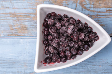 blueberries in a shaped bowl on wooden background