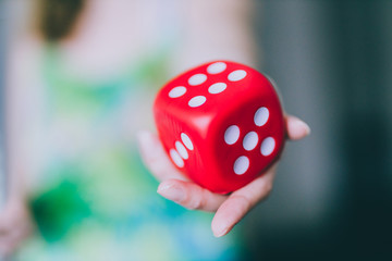 girl handing big red dice shot at shallow depth of field