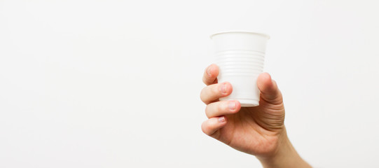 Female male hand holding a plastic cup isolated selective focus