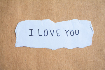 text I love you on brown paper.