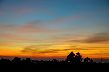 Obraz premium Sunset the evening light through the clouds and trees.