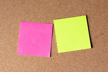 Blank colorful paper sticky note on cork board.