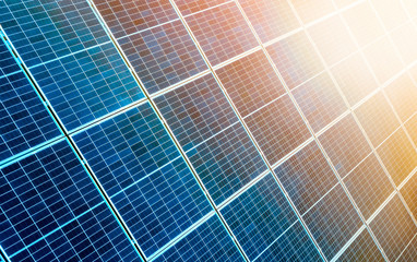 Close-up surface of lit by sun blue shiny solar photo voltaic panels. System producing renewable...