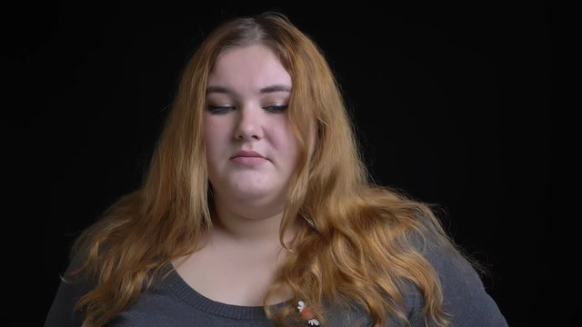 Closeup shoot of overweight caucasian female being upset and depressed looking straight at camera
