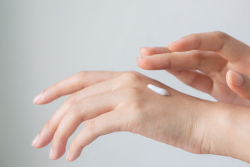 Woman hands applying hand cream.