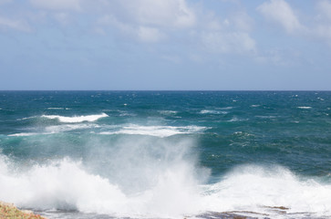 View of Beautiful Surging Ocean Waves Near a Shore. It`s Background of Blue Horizon Line. 