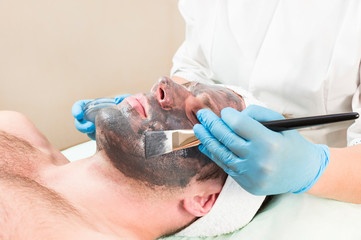 Man in the mask cosmetic procedure in spa salon