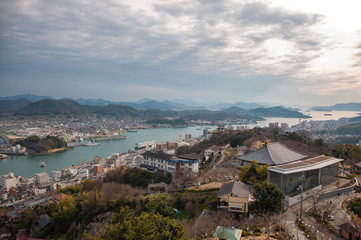 Panoramic, scenic view of Onomichi City and the Seto Inland Sea during sunset as seen from the Senkoji Park Observatory which is located on the summit of Mt. Senkoji in Hiroshima Prefecture in Japan.