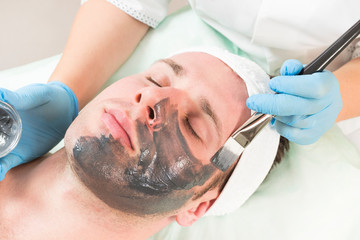 Man in the mask cosmetic procedure in spa salon 