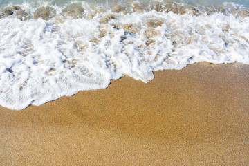 Soft wave of blue sea on sandy beach.