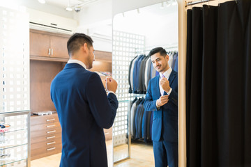Happy man admiring his new suit in tailor shop