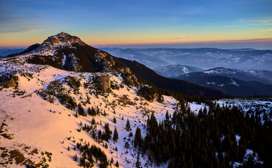 Dochia chalet and Toaca peak at sunrise in Ceahlău Mountains National in winter season,Aerial winter Landscape