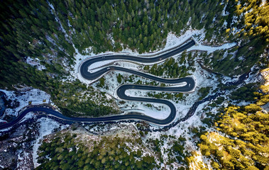 Aerial drone view of a serpentine in rocky mountain forest, Bicaz gorge with winding road in winter season,Cheile Bicazului, Romania
