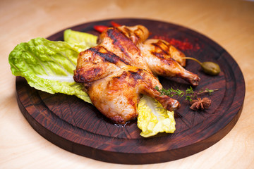 Roast chicken and leaf lettuce on a wooden board