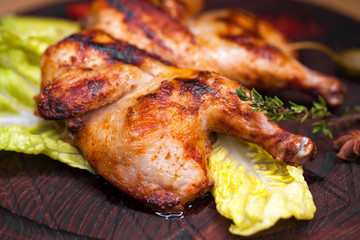 Roast chicken and leaf lettuce on a wooden board