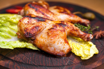Roast chicken and leaf lettuce on a wooden board