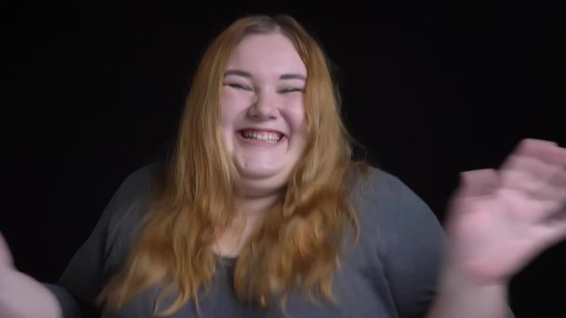 Closeup portrait of young attractive overweight caucasian female being happy and celebrating with fun smiling while looking at camera