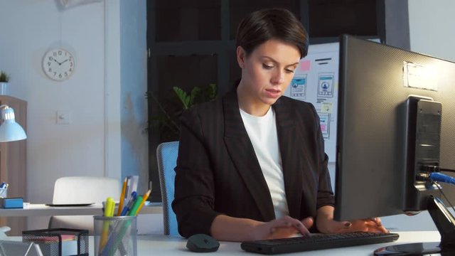 business, deadline and technology concept - businesswoman with computer working at dark night office