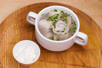 Boiled dumplings with broth in a white cup