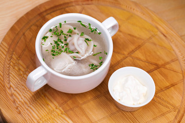 Boiled dumplings with broth in a white cup