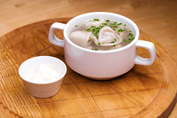 Boiled dumplings with broth in a white cup