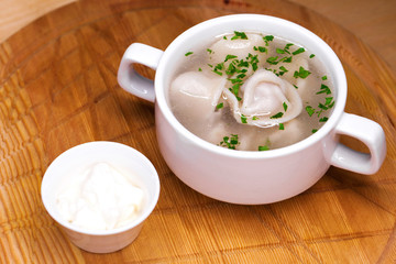 Boiled dumplings with broth in a white cup