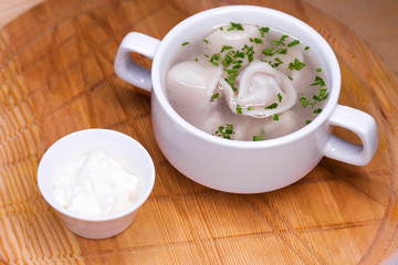 Boiled dumplings with broth in a white cup