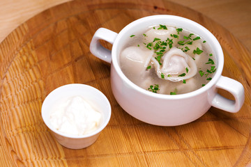 Boiled dumplings with broth in a white cup