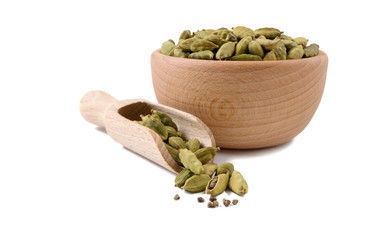 cardamon seeds  in wooden bowl and scoop isolated on white background. Spices and food ingredients.